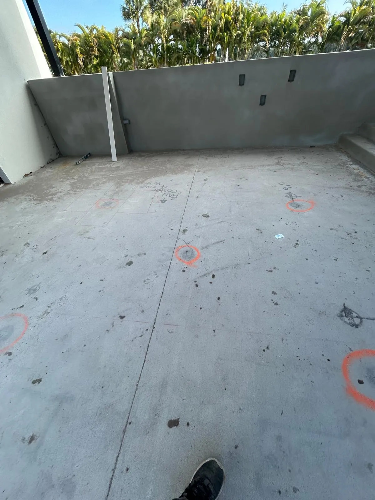 Bare concrete deck slab with orange layout marks before the stone paving went down