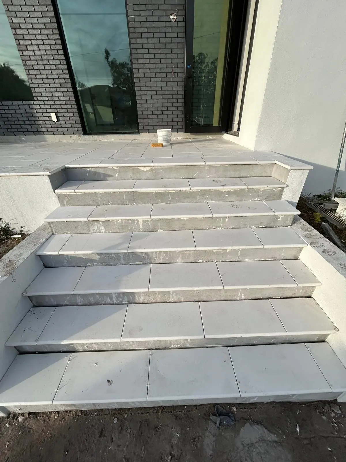 Finished entry steps in white stone with bullnose treads leading up to the front door landing