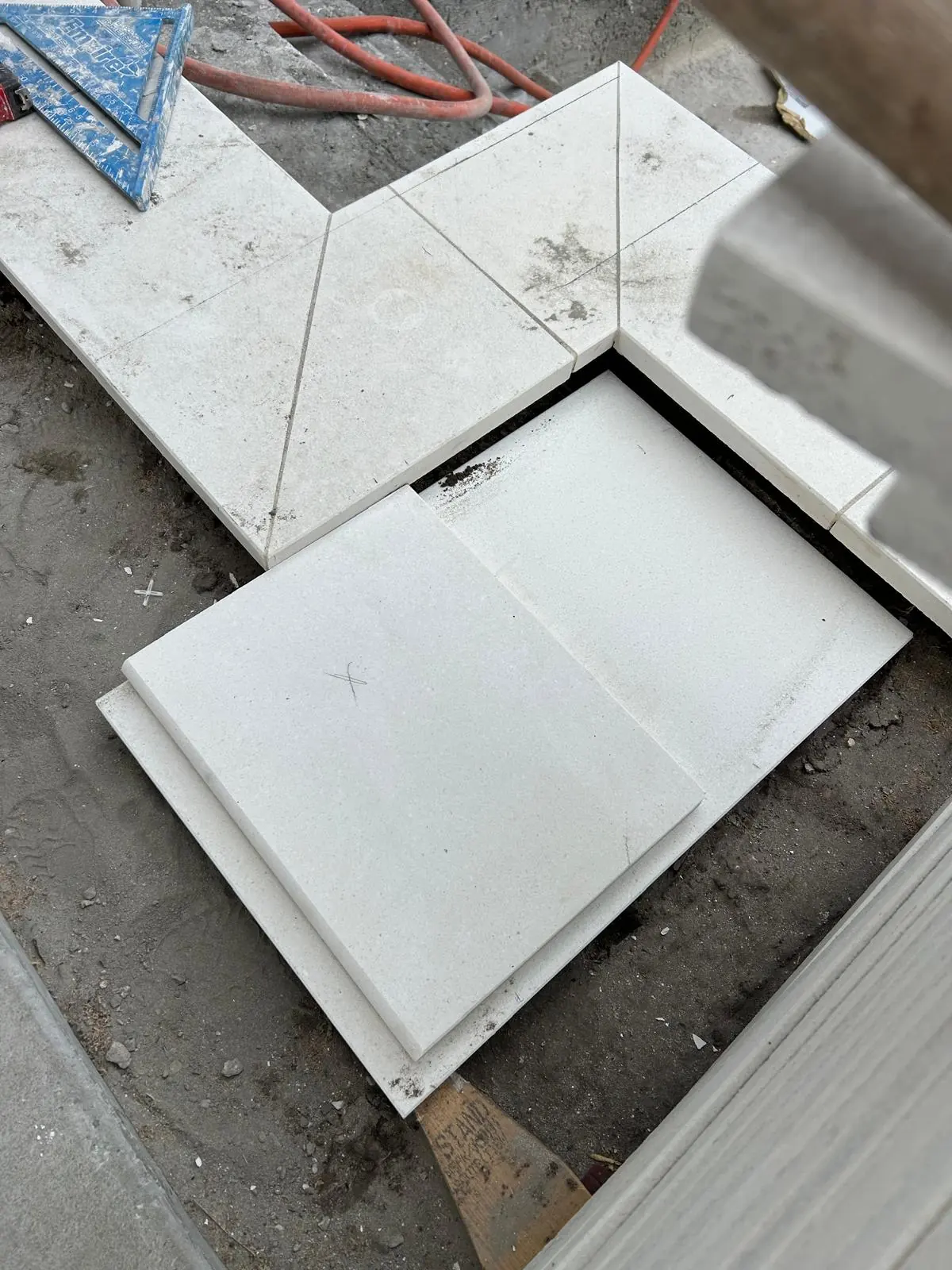 Close view of a mitred outside corner in white stone paving with a rounded bullnose edge
